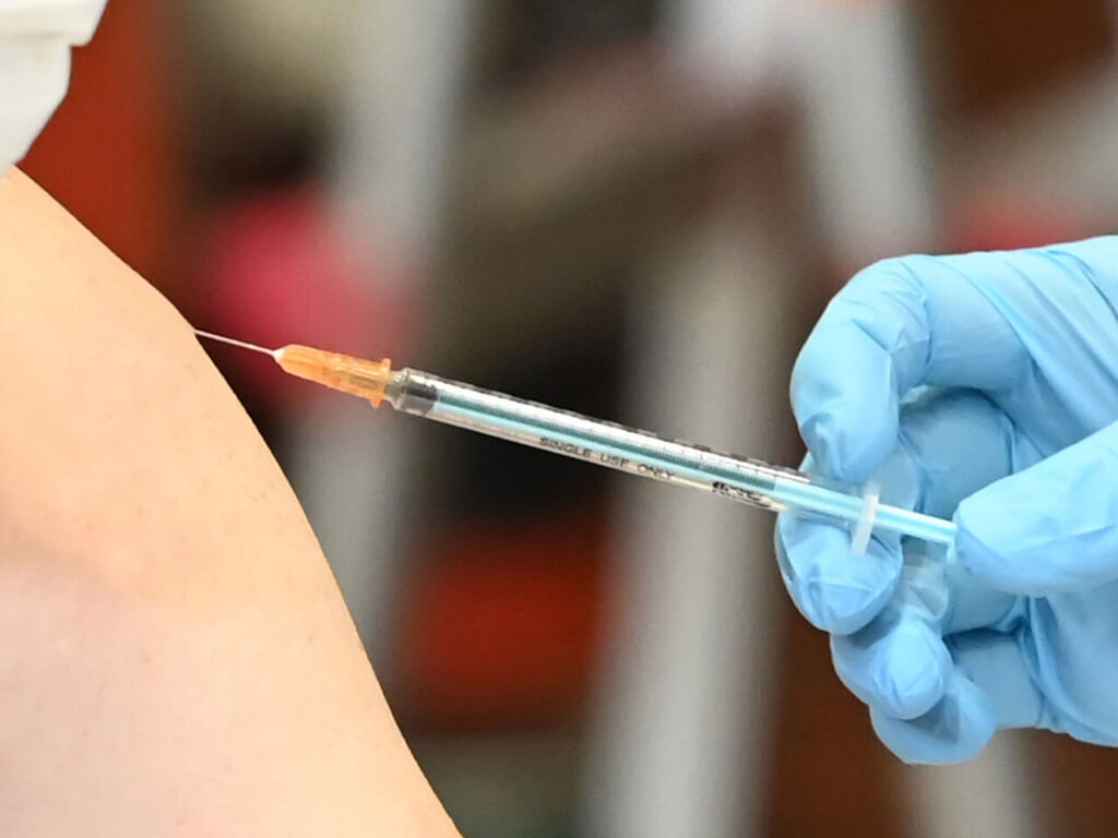 看護師が手袋を着用し注射を行う様子