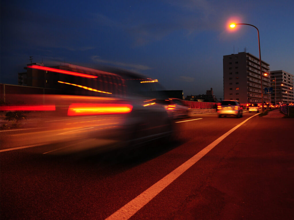 夕方の街を走る車のライトが流れる様子